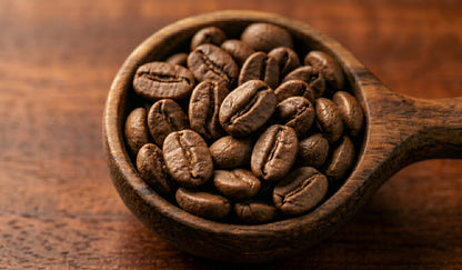 Close‑up of Kenya Kafe Cup medium‑roasted coffee beans in a wooden scoop on a warm wooden surface. Rich brown color and subtle sheen highlighting balanced roast depth and smooth texture